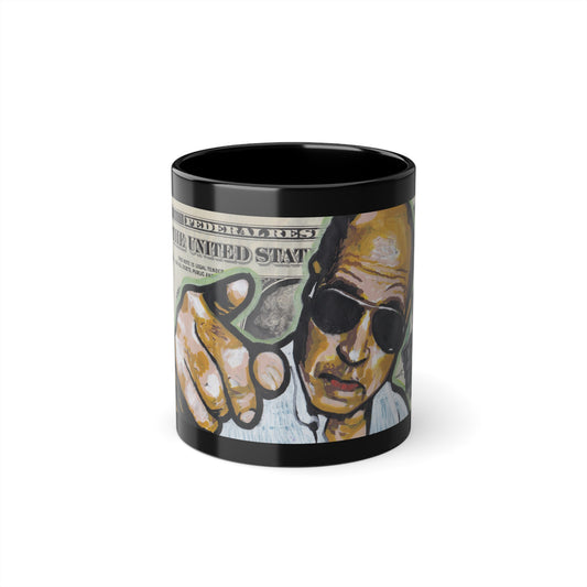 The image features a black coffee cup with a glossy finish that highlights a vivid and colorful graphic of a man wearing sunglasses, set against a textured background that includes the depiction of a gun and some indistinct designs. The cup, made from durable black ceramic material, front